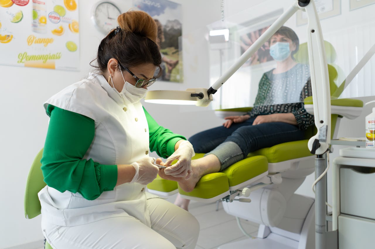 who-we-are-03 Concentrated professional master in beauty salon wearing medical mask doing pedicure during coronavirus epidemic